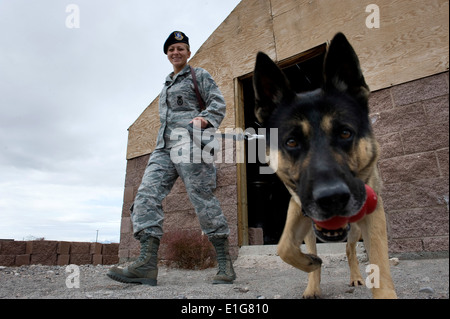 US Air Force Staff Sgt Bobbie Ohm, ein militärischer Arbeitshund Handler mit dem 99. Sicherheit Kräfte Geschwader geht mit Nero, ein Stockfoto