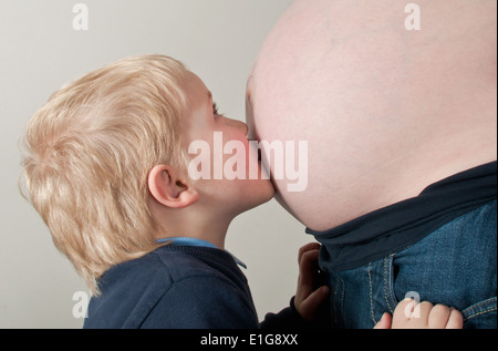 Kleine Junge küssen Schwangerschaft Beule Stockfoto