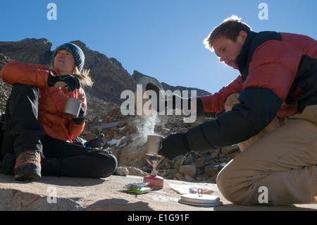 Ein Mann und eine Frau kochendes Wasser auf einem Campstove oberhalb der Baumgrenze in der Nähe von Telluride, Colorado. Stockfoto