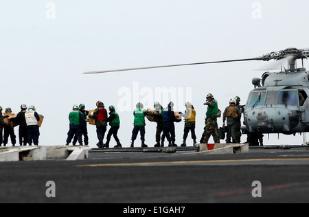 110315-N-GL340-170 westlichen Pazifischen Ozean (15. März 2011) - Segler bewegen, Nahrung und Wasser auf ein HH - 60 H Sea Hawk zugewiesen die Stockfoto