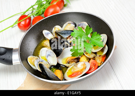 Braten Sie, Fisch und Meeresfrüchte in einer Pfanne mit Olivenöl und Petersilie Stockfoto