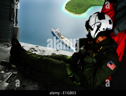 US Navy Naval Air Crewman 2. Klasse Bowen Derik, Recht, befestigt an Hubschrauber Meer bekämpfen Squadron (HSC) 23 Uhren der Amphi Stockfoto