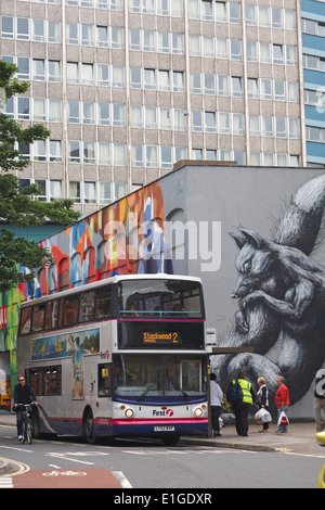 Radfahrer vorbei an Bus, Abholung, die Passagiere im Bus von Straßenkunst Graffiti an Nelson Street, Bristol zu stoppen Stockfoto