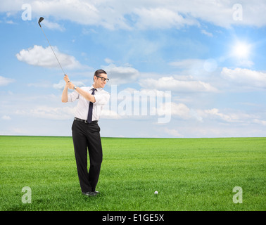 Junger Mann, Golfen auf einem Feld isoliert auf weißem Hintergrund mit Tilt-Shift-Objektiv geschossen Stockfoto