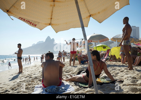 RIO DE JANEIRO, Brasilien - 23. Januar 2014: Sonnenanbeter verteilt gegen einen Blick auf zwei Brüder Berg am Strand von Ipanema. Stockfoto