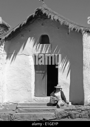 Eine Atacapeno Frau sitzt vor der Iglesia San Carlos im Dorf Machuca, Chile Stockfoto