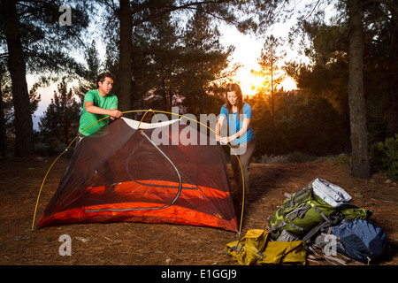Ethnische paar pitching ein Zelt auf einer Rucksacktour in den Bergen. Stockfoto
