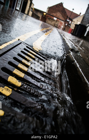 Strom für den Betrieb von Regenwasser geht über den Abfluss in ein schweres Gewitter. Stockfoto