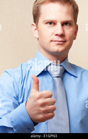 Junger Geschäftsmann zeigt Daumen hoch Zeichen Stockfoto