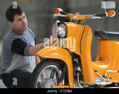 Suhl, Deutschland. 4. Juni 2014. Mitarbeiter Horst Sosnowski reinigt eine Simson Schwalbe im Musée Vehicel in Suhl, Deutschland, 4. Juni 2014. Das klassische Motorrad aus der DDR feiert seinen 50. Geburtstag im Juli. Foto: MARTIN SCHUTT/Dpa/Alamy Live News Stockfoto