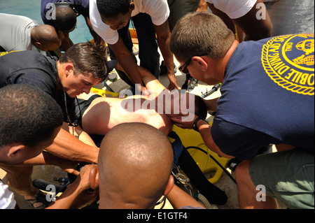 Mitglieder des Mobile Tauch- und Salvage Unit (MDSU) 2 und multinationale Taucher laden U.S. Navy Chief Hospital Corpsman Nathanael Wa Stockfoto