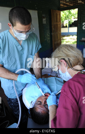 U.S. Navy Captain Wendy Boruszewski, rechts, reinigen Hospitalman David Anton, links, und Zähne des Patienten an der Escuela Humberto mich Stockfoto