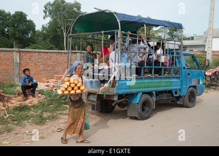 LKW Bus Menschen pendeln, auf Fahrrädern auf einer staubigen Straße, in Kambodscha, LKW, Stockfoto