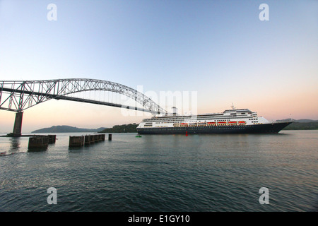 Kreuzfahrt Schiff unter der Brücke der Amerikas bei Sonnenaufgang. Das Schiff ist der Panama-Kanal auf der pazifischen Seite betreten. Stockfoto