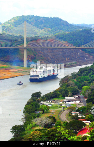 Kreuzfahrt Schiff unterhalb der Centennial Bridge über den Panama-Kanal. Üppiger Landschaft umgibt den Kanal, Panama. Stockfoto