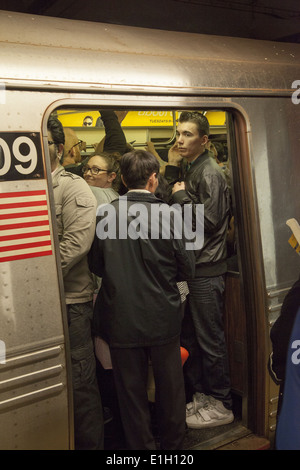 U-Bahn-Züge und Plattformen sind im Feierabendverkehr in Manhattan verpackt. Broadway / Lafayette Stop, SOHO. Stockfoto