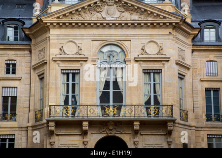 Mann aus dem Fenster des Ministeriums für Kultur und Kommunikation Gebäudes befestigt, Palais Royal, Paris Frankreich Stockfoto
