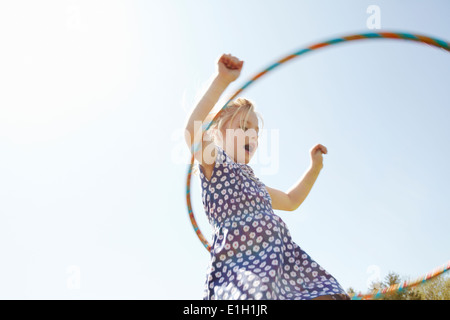 Niedrigen Winkel Blick auf Mädchen spielen mit Kunststoff hoop Stockfoto