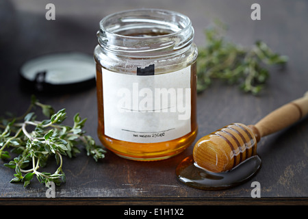 Glas Honig mit Kräutern Stockfoto