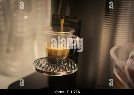 Ein Nespresso Marke einschüssigen Kaffee Brauer gießt einen Espresso an einer Werbeveranstaltung in New York Stockfoto