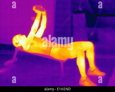 Wärmebild eines Mannes mit Langhantel training. Das Bild zeigt die Wärmeentwicklung durch die Muskeln Stockfoto