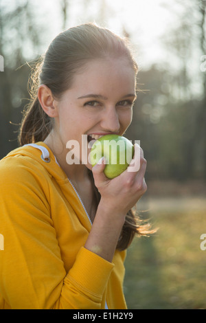 Porträt der jungen weiblichen Läufer einen Apfel essen Stockfoto