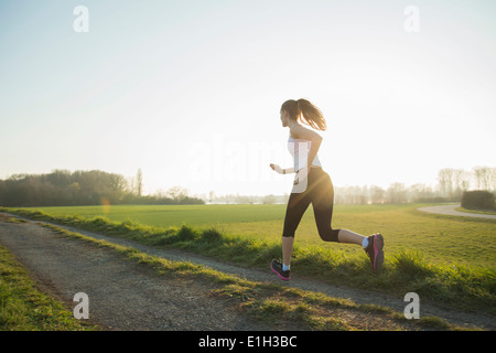 Junge weibliche Läufer auf Feldweg Stockfoto