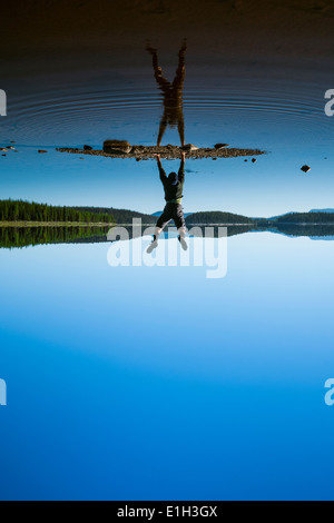 Mann tut Handstand am McCulloch Lake entlang der "KVR" Trail, Okanagan Highlands, British Columbia, Kanada Stockfoto