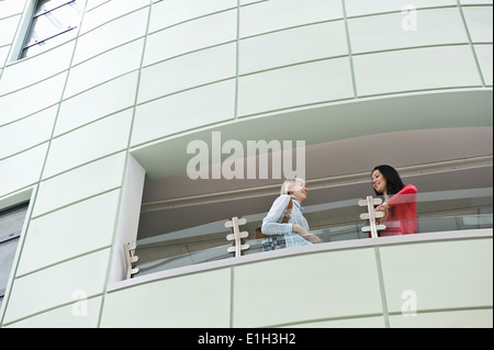 Zwei junge Frauen reden auf Balkon, niedrigen Winkel Stockfoto