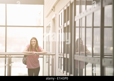 Junge Frau lehnt sich am Geländer Stockfoto