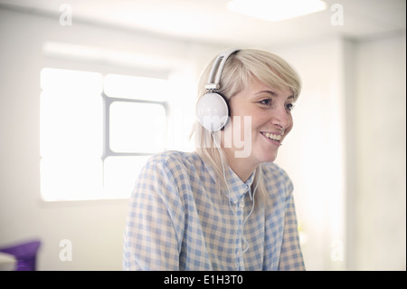 Junge Frau Kopfhörer anhören Stockfoto