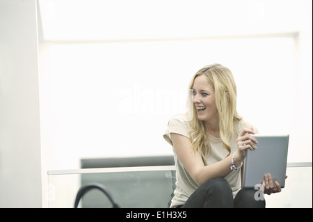 Junge Frau mit digital-Tablette zu lachen Stockfoto