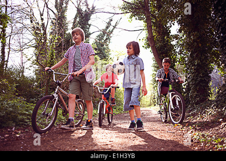 Jungen mit Fahrrädern auf Waldweg Stockfoto