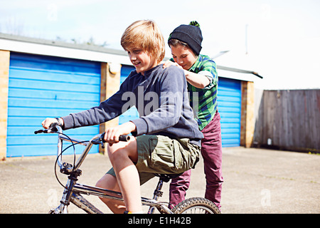 Junge Freund geben eine Fahrt auf Rückseite Fahrrad