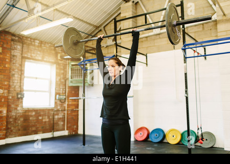 Frau heben Langhantel im Fitness-Studio Stockfoto