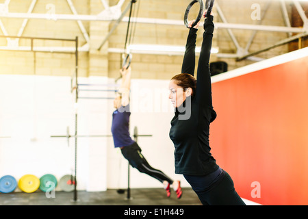 Paar ziehen hängende Ringe in Fitness-Studio Stockfoto