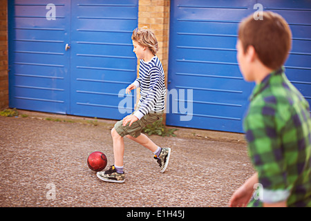 Zwei Jungs spielen Fußball mit garage Stockfoto