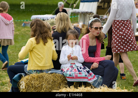 Junge Mädchen auf Strohballen sitzend Stockfoto