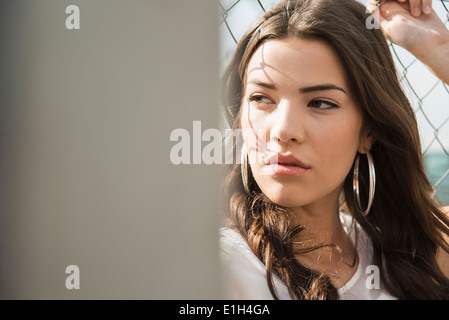 Junge Brünette Frau trägt Ohrringe Stockfoto