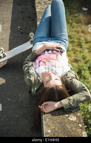 Junge Frau liegt auf Wand schlafen Stockfoto