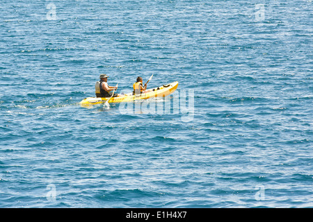 Junges Paar Kajakfahren in den Ozean weg von der Waterfront in Avalon, Santa Catalina, Kalifornien. Stockfoto