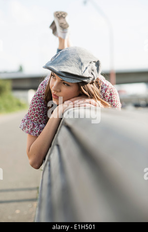 Junge Frau am vorderen tragen flache Kappe liegen Stockfoto