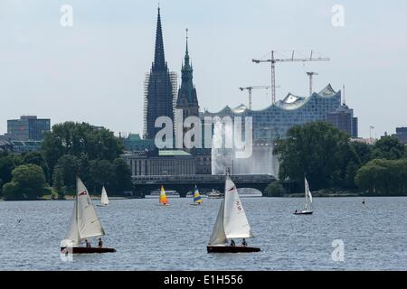 Hamburg, Deutschland. 4. Juni 2014. Segler fahren ihre Boote bei Sonnenschein am Fluss Alster in Hamburg, Deutschland, 4. Juni 2014. Der Turm der St.-Nikolaus Kirche ist im Gerüstbau im Hintergrund bedeckt. Hamburger Rathaus ist auf der rechten Seite neben der Bau aus den Augen die Elbphilharmonie auf der rechten Seite gesehen. Foto: BODO MARKS/Dpa/Alamy Live-Nachrichten Stockfoto