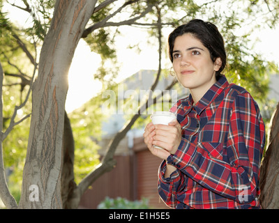 Porträt der lächelnde junge Frau mit Kaffee zum mitnehmen Stockfoto