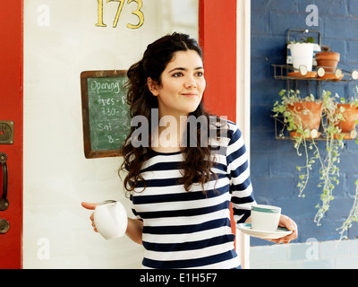 Junge Kellnerin serviert Kaffee im freien Stockfoto