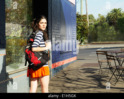 Junge Frau auf der Straße Suche über die Schulter Stockfoto