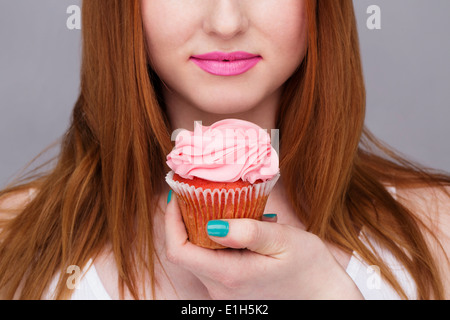 Bild junge Frau mit Cupcake beschnitten Stockfoto