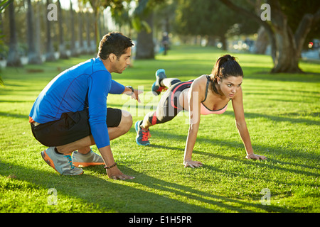 Personal Trainer mit Frau Plank Übung Stockfoto