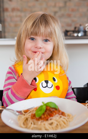 Porträt von 2 Jahre altes Mädchen essen Spaghetti mit Fingern Stockfoto