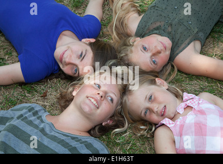 Vier Mädchen auf dem Rasen liegend Stockfoto